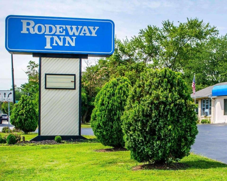a blue road way inn sign next to a bush at Rodeway Inn in Dillsburg