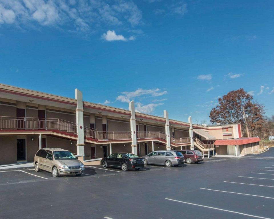 un hotel con coches estacionados en un estacionamiento en Econo Lodge, en Hermitage