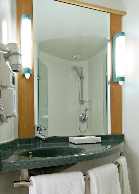 a bathroom with a green sink and a mirror at ibis Pune Viman Nagar - An Accor Brand in Pune