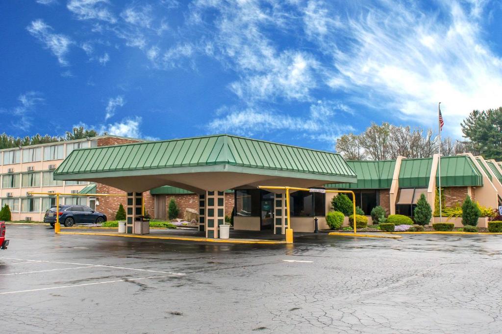 a gas station with a green roof in a parking lot at Quality Inn in Hermitage