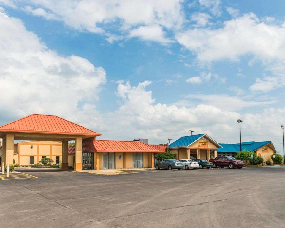 un hotel con coches estacionados en un estacionamiento en Rodeway Inn, en Mercer