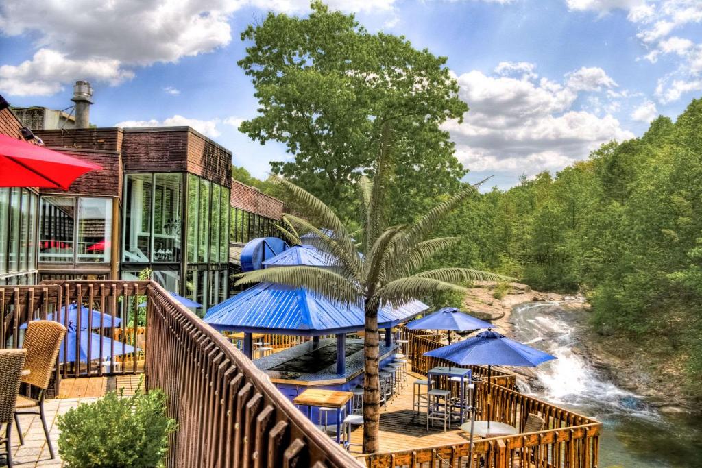 
a patio area with umbrellas and a boat on the water at The Woodlands Inn, Ascend Hotel Collection in Wilkes-Barre
