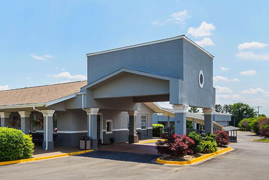 Quality Inn & Suites Greenville - Haywood Mall في غرينفيل: مبنى أزرق كبير مع موقف للسيارات