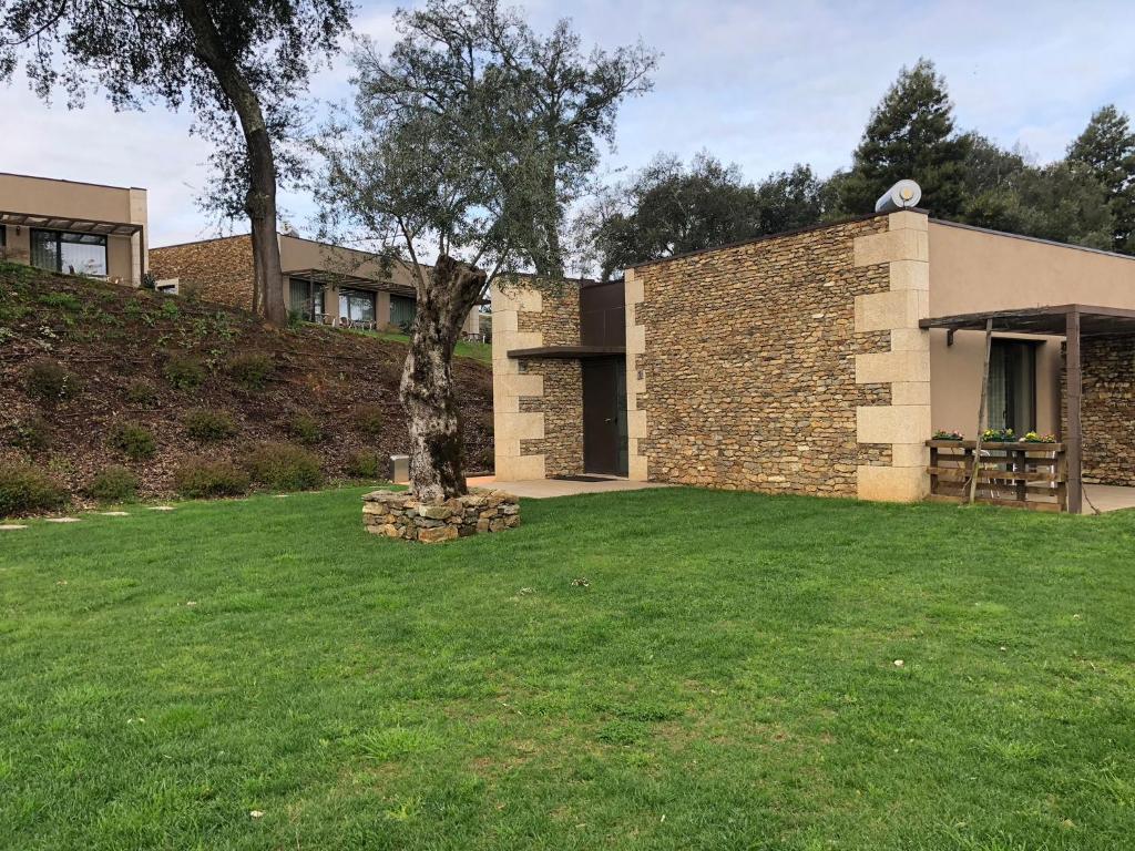 una casa con un árbol en el patio en Bosque da Harmonia, en Arco de Baúlhe