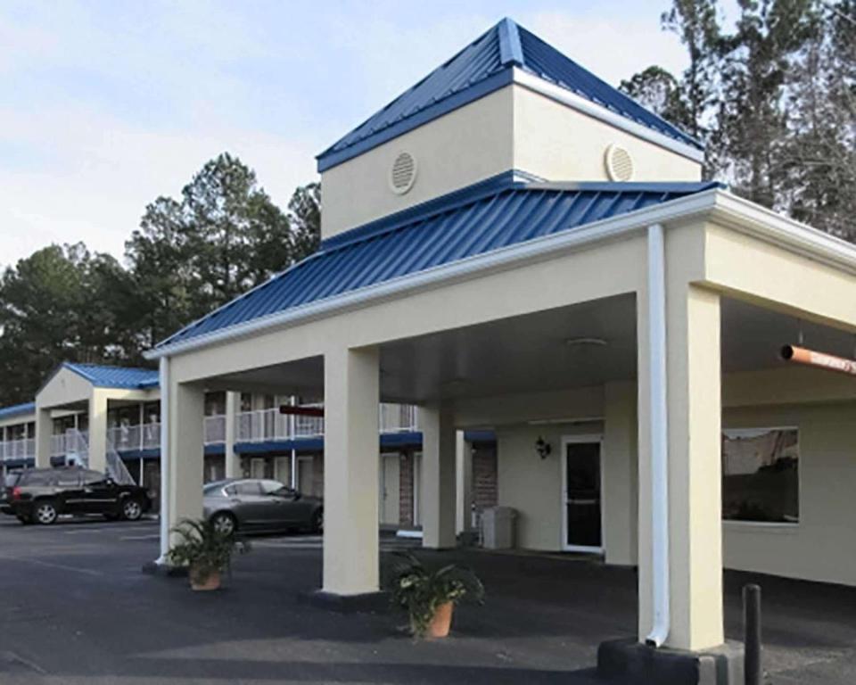 een gebouw met een blauw dak en een parkeerplaats bij Rodeway Inn Walterboro I-95 in Walterboro