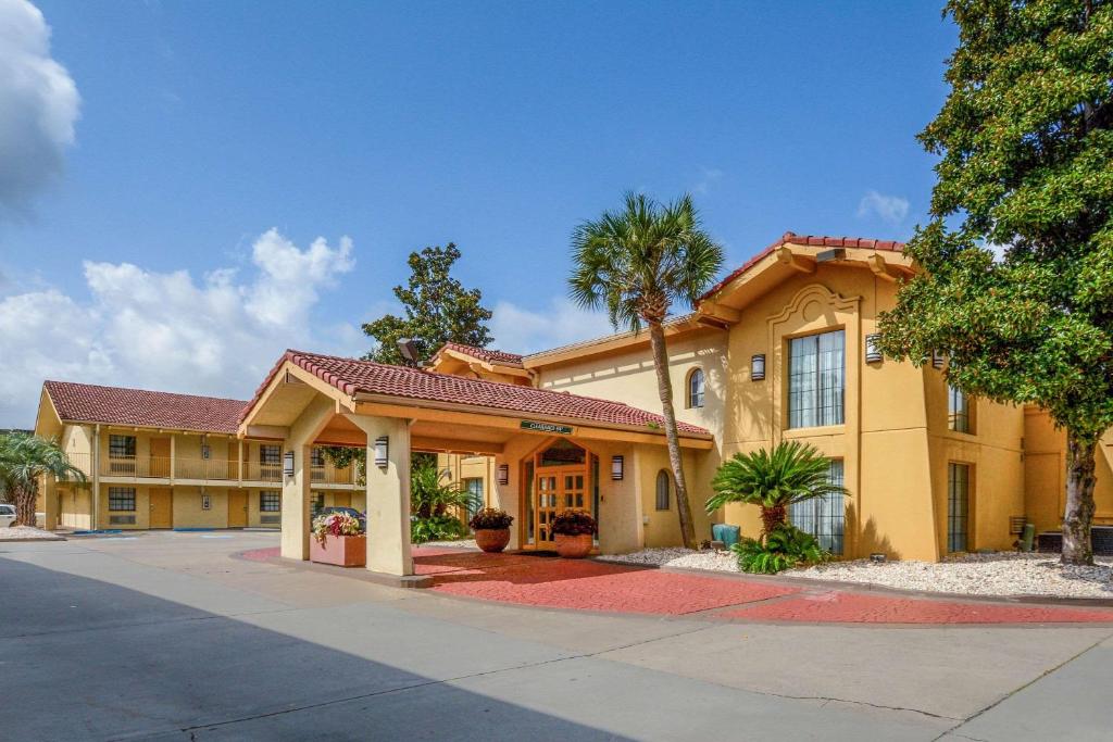 a large yellow building with palm trees in front of it at Quality Inn & Suites North Charleston - Ashley Phosphate in Charleston