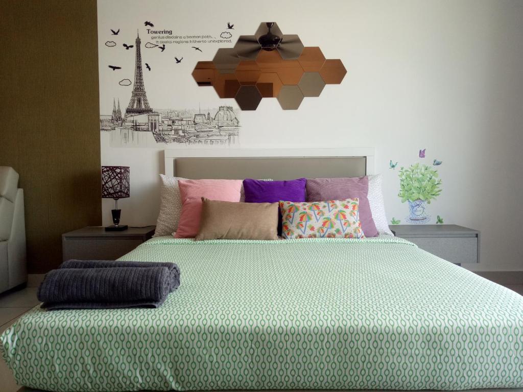 een slaapkamer met een groot bed met kleurrijke kussens bij Bangi Studio Suite in Kampong Sungai Ramal Dalam