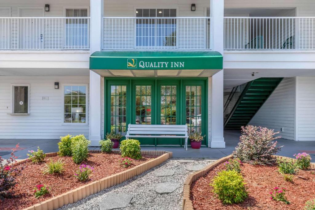 a building with a bench in front of a building at Quality Inn in Cheraw