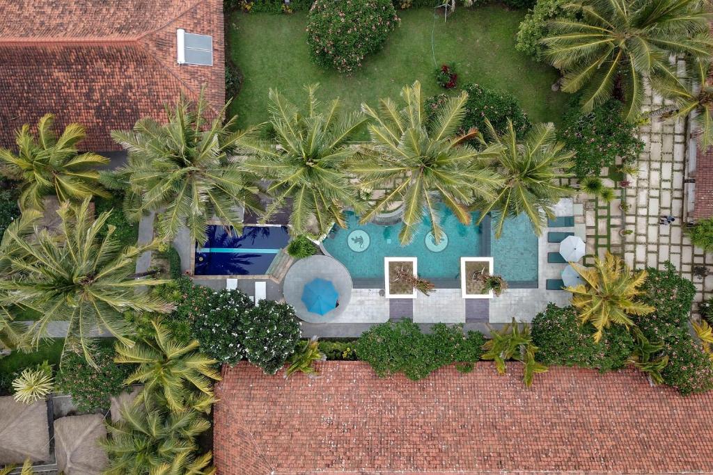 an overhead view of a resort with a swimming pool and palm trees at Segara Anak Hotel in Kuta Lombok