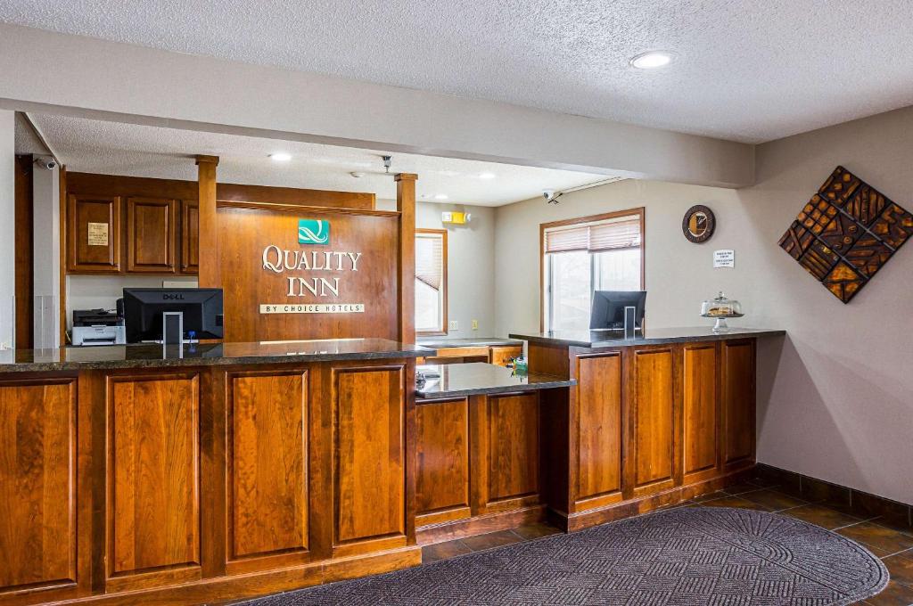 a kitchen with wooden cabinets and a counter top at Quality Inn in Mitchell