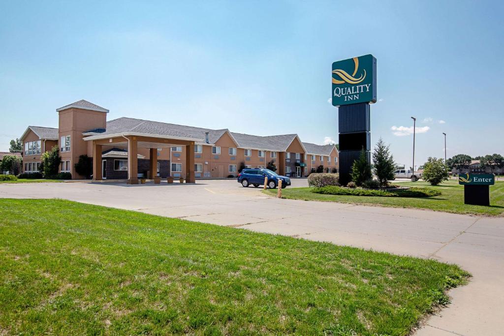 a sign in front of a building with a car dealership at Quality Inn Huron in Huron