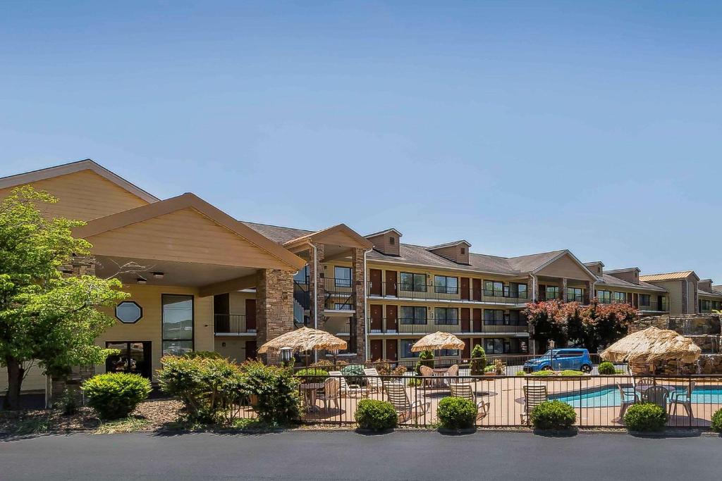a hotel with a pool and chairs and umbrellas at Quality Inn & Suites Sevierville - Pigeon Forge in Sevierville