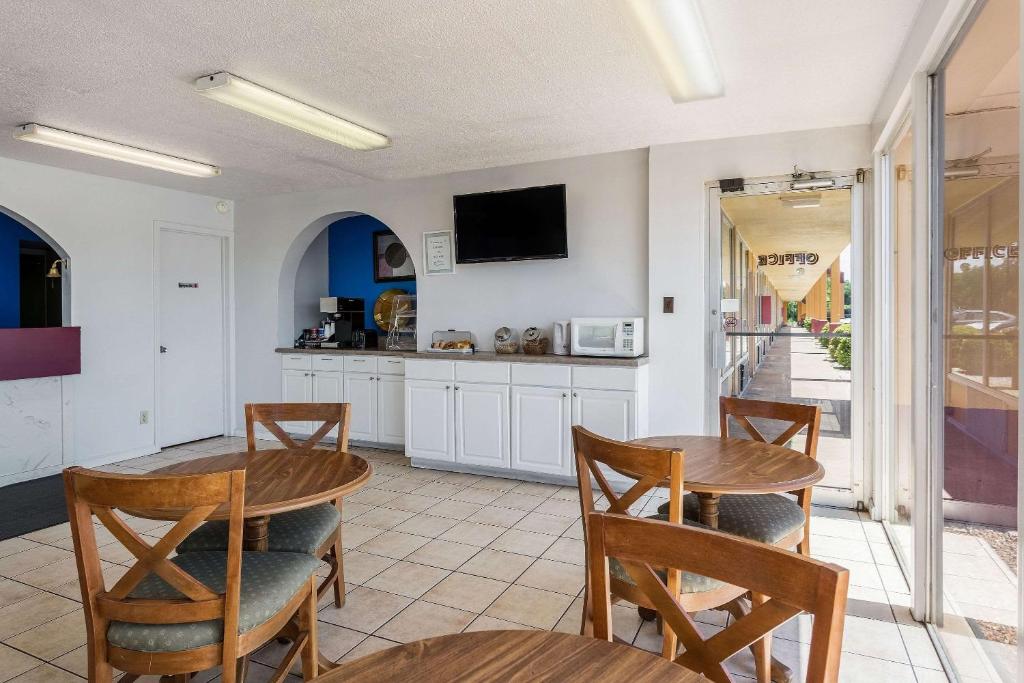 a kitchen with two wooden tables and chairs at Rodeway Inn Denmark-Jackson in Denmark