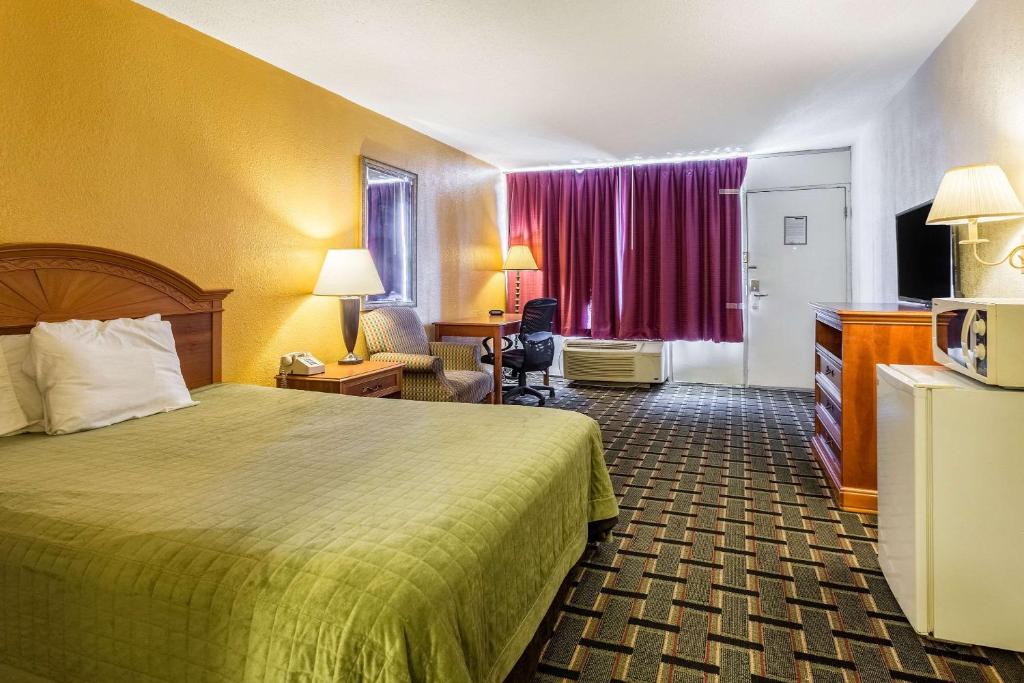 a hotel room with a bed and a desk and chair at Rodeway Inn Denmark-Jackson in Denmark