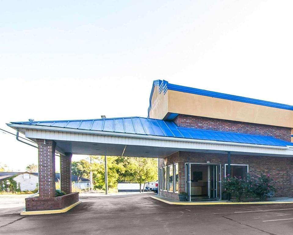 una gasolinera con un edificio con techo azul en Rodeway Inn, en Sweetwater