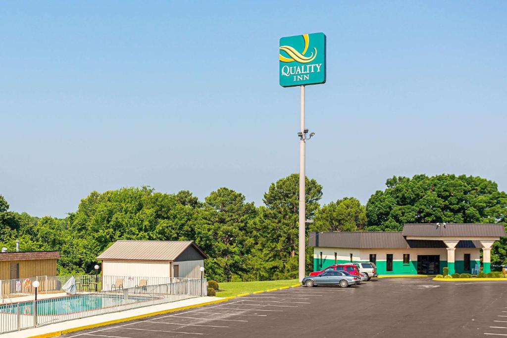 a parking lot with a sign for a quality inn at Quality Inn in Hurricane Mills
