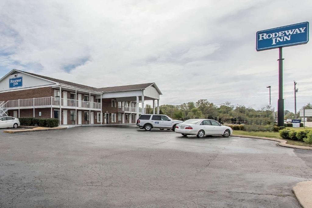 een hotel met twee auto's geparkeerd op een parkeerplaats bij Rodeway Inn Jackson in Jackson