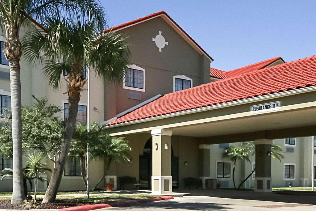 a front view of a hotel with palm trees at Quality Inn Kingsville Hwy 77 in Kingsville