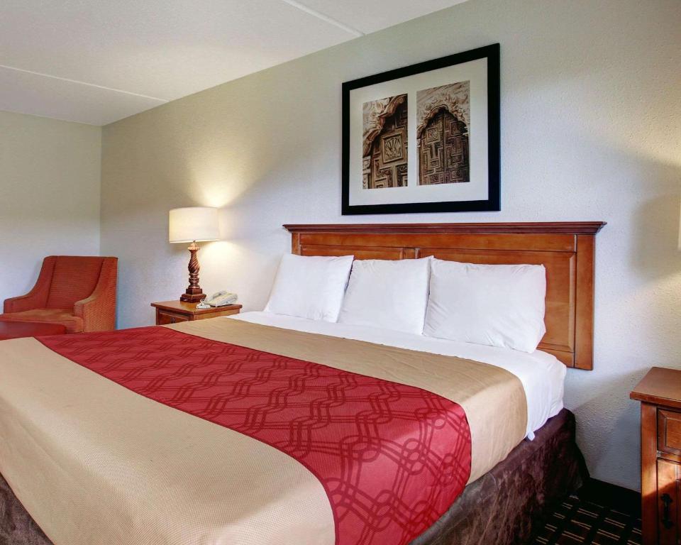 a hotel room with a large bed and a chair at Rodeway Inn New Braunfels in New Braunfels