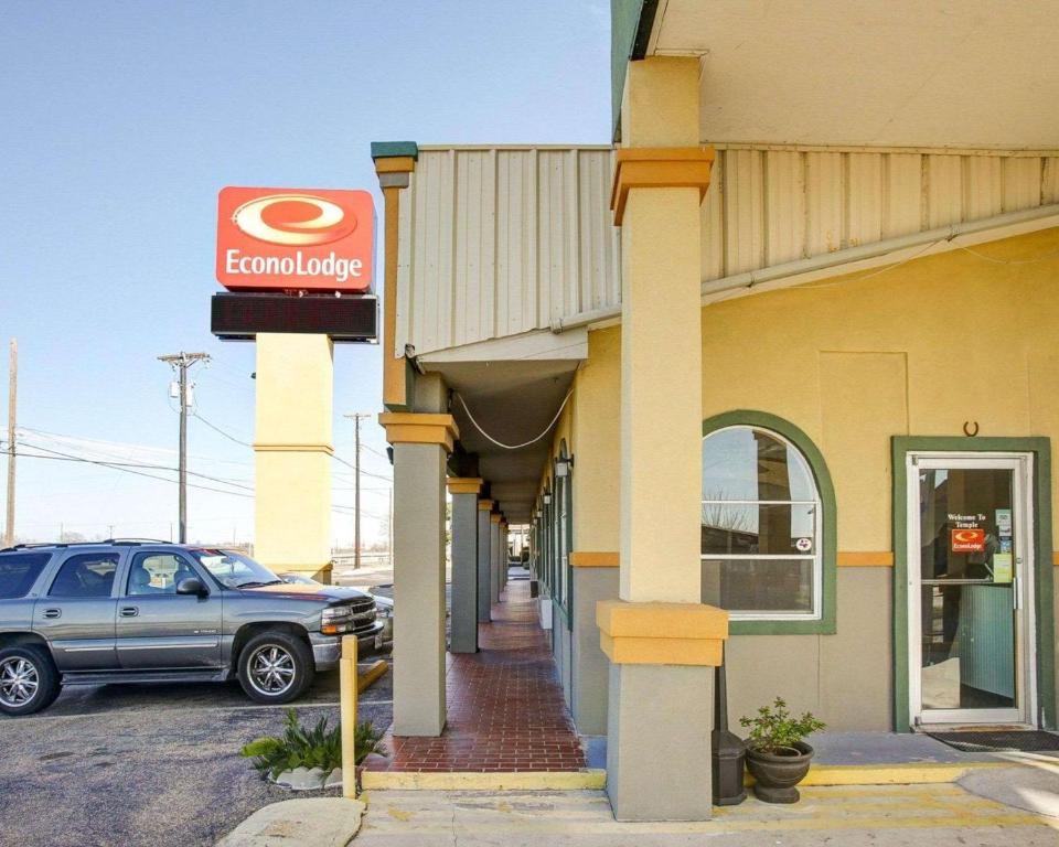 a car parked outside of a building with a car dealership at Econo Lodge Temple in Temple