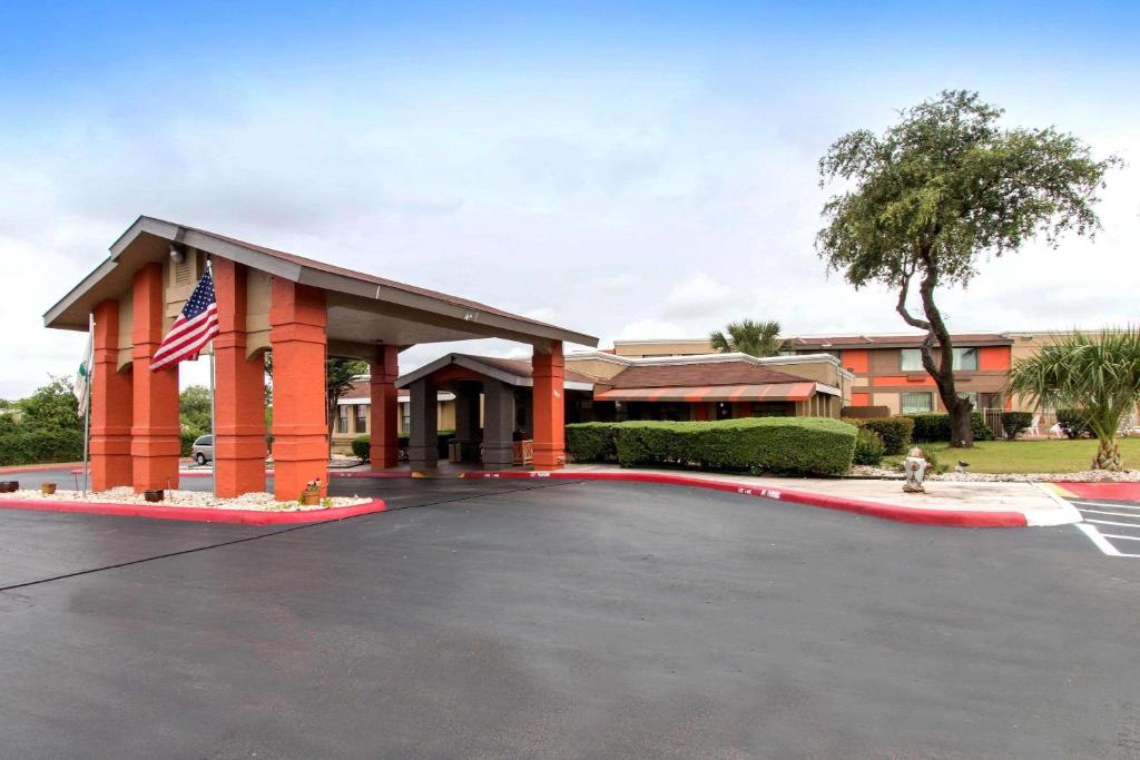 a building with an american flag in a parking lot at Quality Inn & Suites I-35 near Frost Bank Center in San Antonio