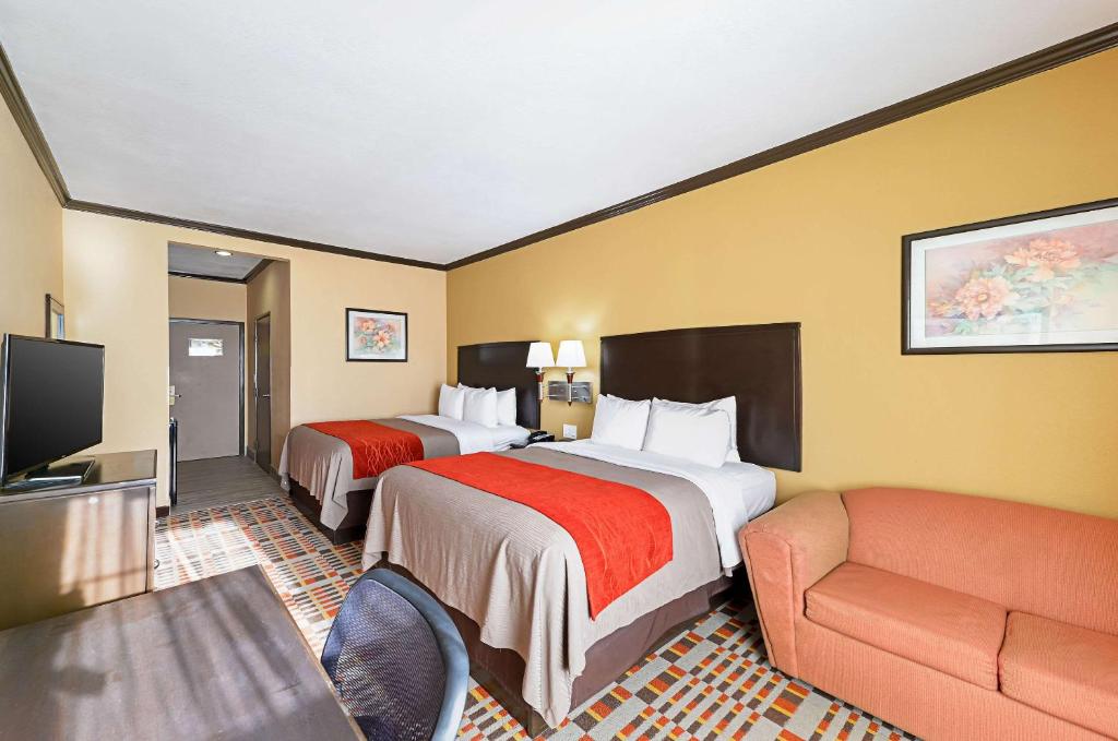 a hotel room with two beds and a couch at Quality Inn & Suites in Lubbock