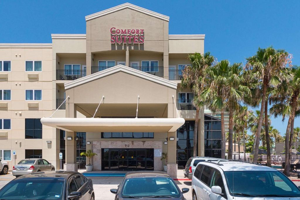 un edificio con coches estacionados en un estacionamiento en Comfort Suites Beachside en South Padre Island