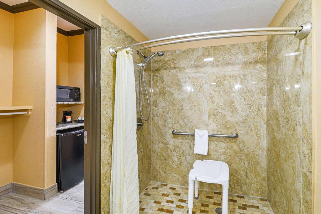 a shower with a white chair in a bathroom at Quality Inn & Suites in Lubbock