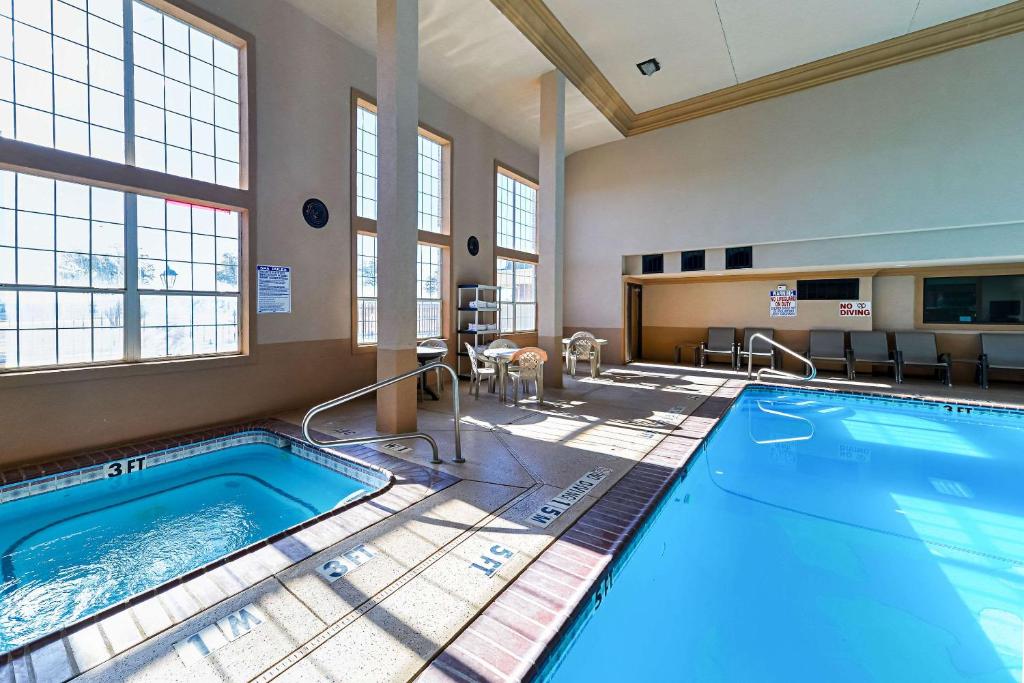 a pool in a large room with windows and a swimming pool at Quality Inn & Suites in Lubbock