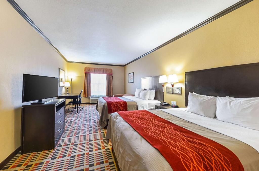 a hotel room with two beds and a desk at Quality Inn & Suites in Lubbock
