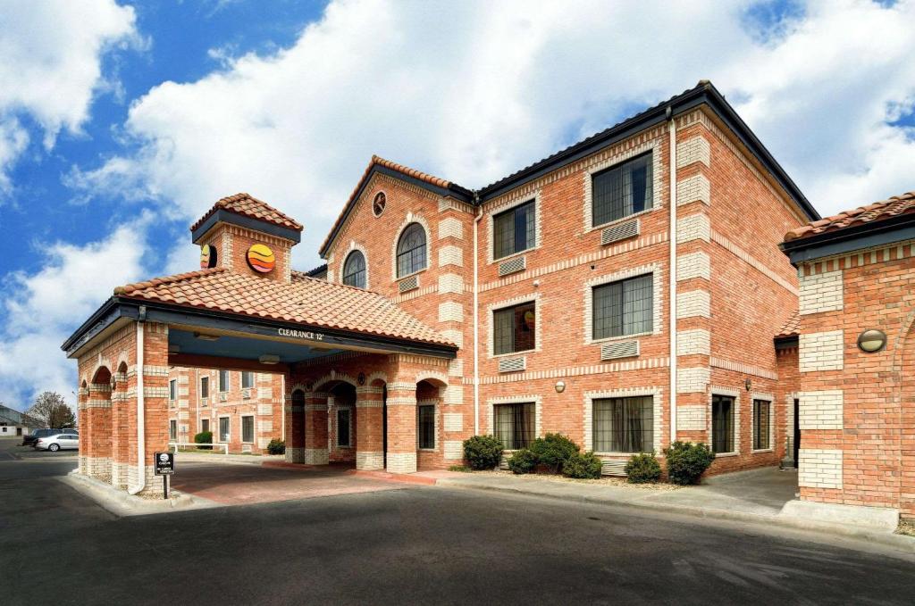 ein großes Backsteingebäude mit einem Uhrturm darauf in der Unterkunft Comfort Inn and Suites Medical West in Amarillo