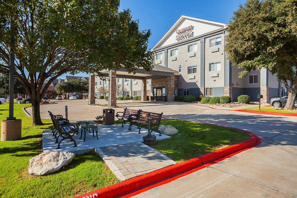 un grupo de bancos frente a un hotel en Comfort Suites Lewisville, en Lewisville