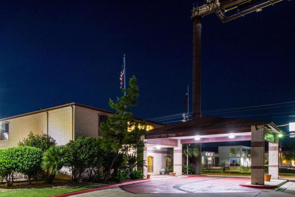 a building with a flag on top of it at night at Quality Inn University near Downtown in San Marcos