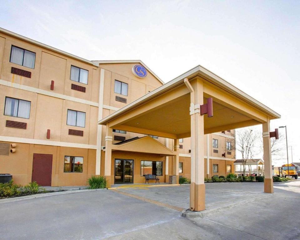 un gran edificio con aparcamiento cubierto enfrente en Comfort Suites Brenham, en Brenham