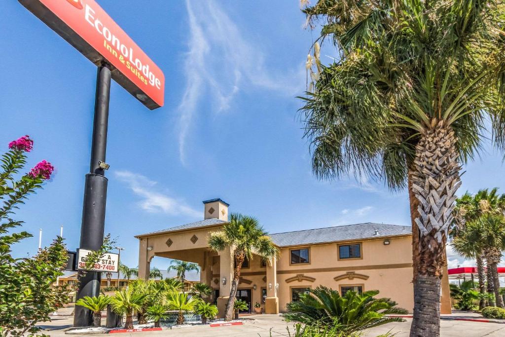 a hotel with palm trees and a street sign at Econo Lodge Inn & Suites Corpus Christi in Corpus Christi