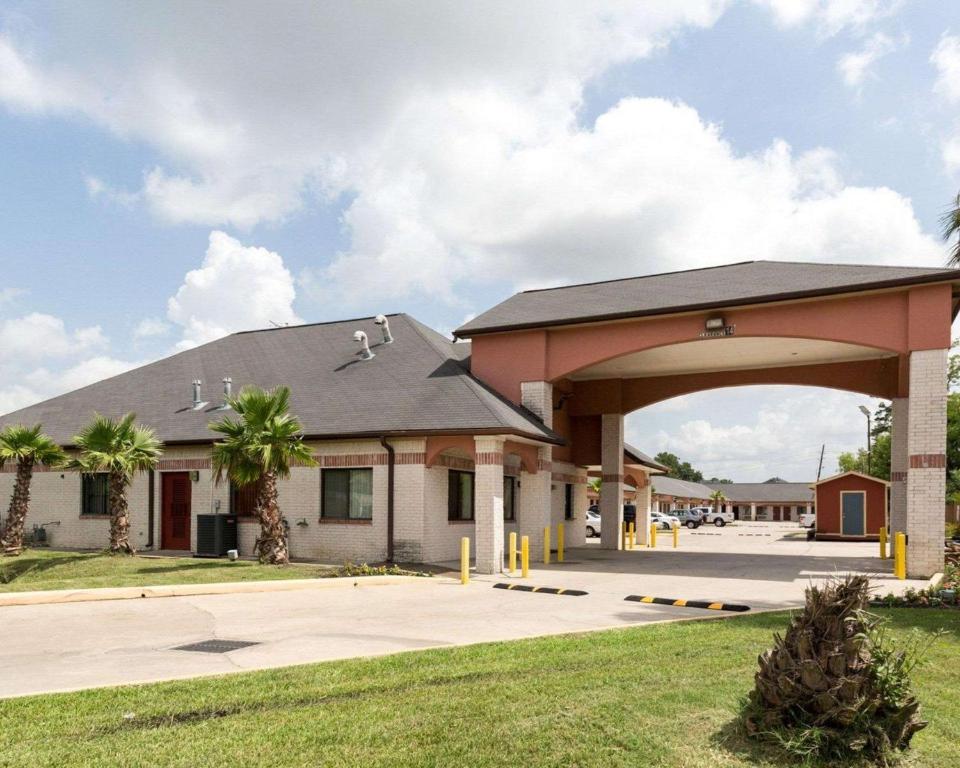 un edificio con un arco delante de él en Scottish Inn & Suites IAH West, en Westfield