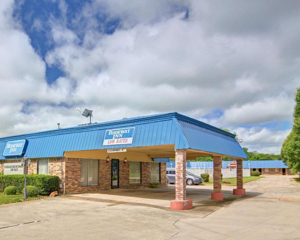 een tankstation met een blauw dak bij Rodeway Inn Gainesville I-35 in Gainesville