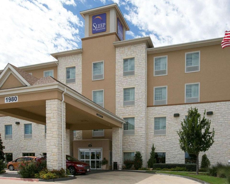 un bâtiment d'hôtel avec une tour d'horloge en haut dans l'établissement Sleep Inn and Suites Round Rock - Austin North, à Round Rock