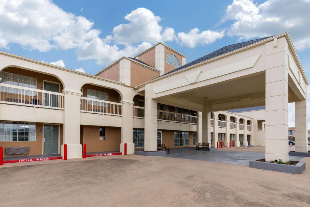 a large building with a church in the background at Quality Inn Clute Freeport in Clute