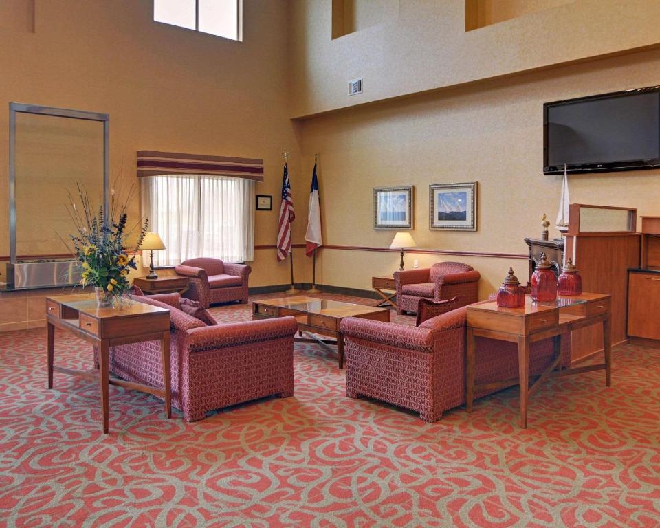a large living room with couches and a flat screen tv at Quality Suites Near Cedar Creek Lake in Mabank