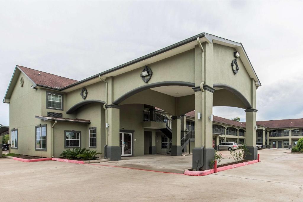 a large building with an archway in a parking lot at Quality Inn & Suites Bridge City Orange in Bridge City