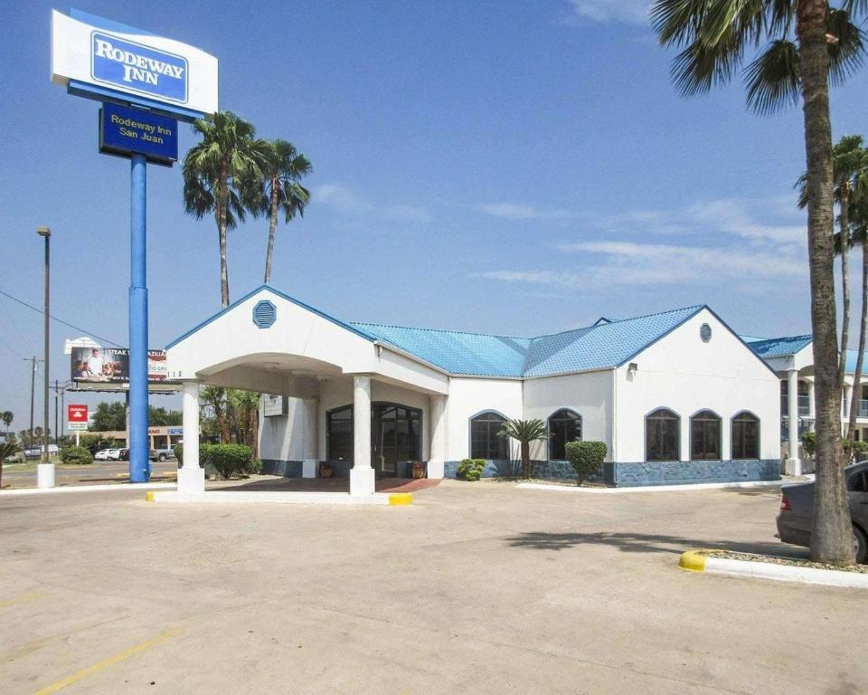 a gas station with palm trees in a parking lot at Rodeway Inn San Juan in San Juan