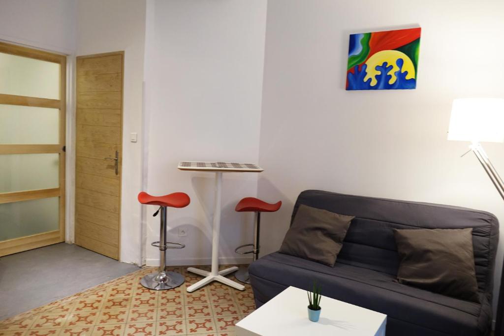 - un salon avec un canapé et deux tabourets dans l'établissement Studio charmant intra-muros, à Avignon