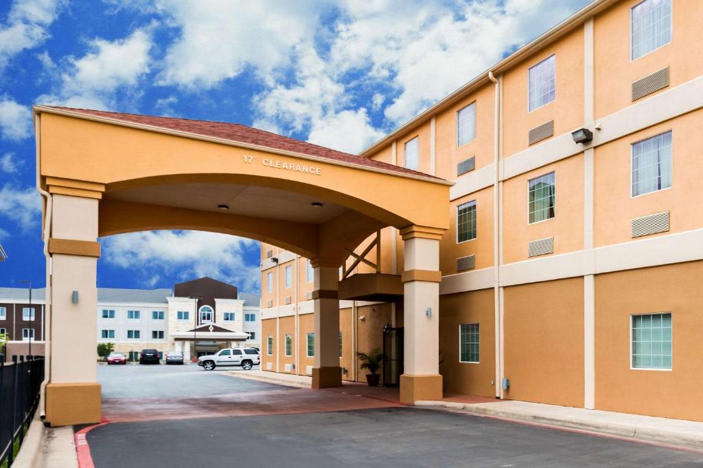 Quality Inn Killeen Forthood في كيلين: مبنى كبير مع ممر في موقف للسيارات