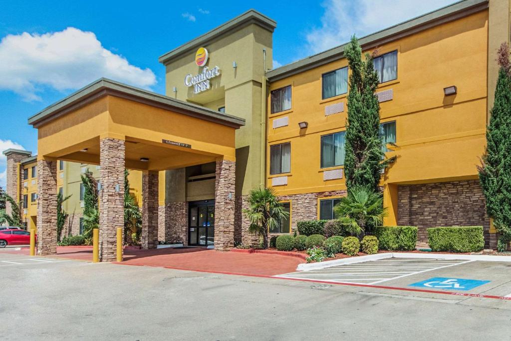 un bâtiment d'hôtel avec un parking en face de celui-ci dans l'établissement Comfort Inn Dallas Park Central, à Dallas