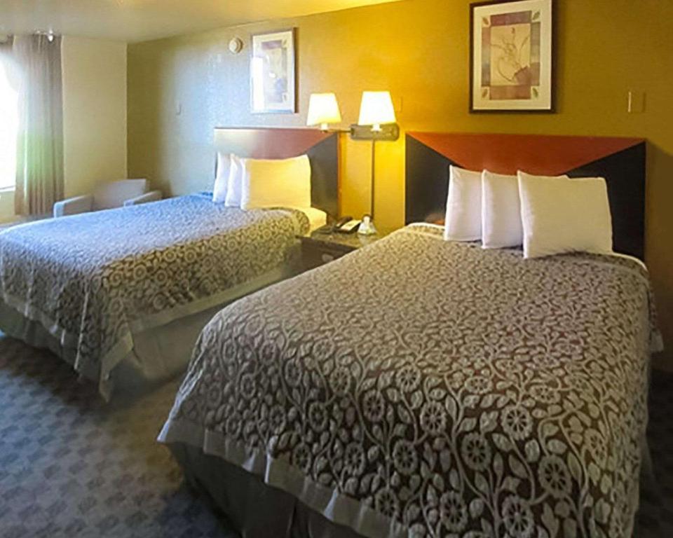 Postel nebo postele na pokoji v ubytování Rose City Inn & Suites