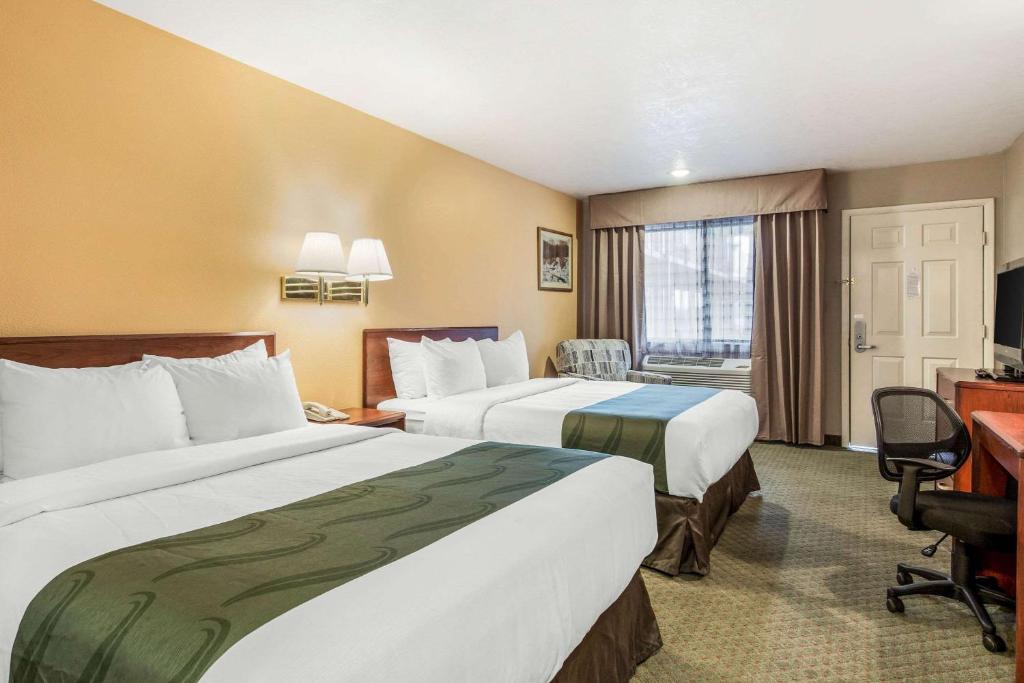 a hotel room with two beds and a desk at Quality Inn Cedar City - University Area in Cedar City
