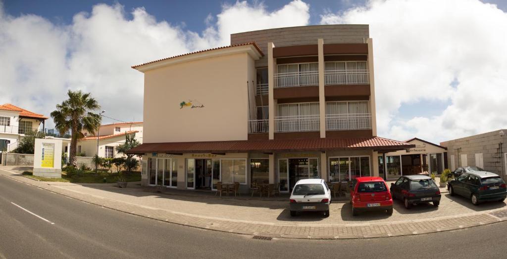 een gebouw waar auto's voor geparkeerd staan bij Areia Dourada in Porto Santo
