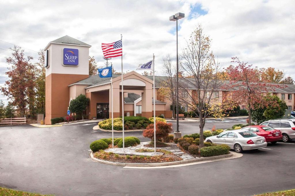 a hotel with cars parked in a parking lot at Sleep Inn in Woodbridge