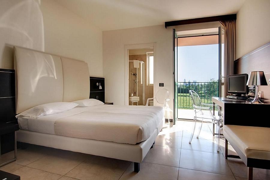 ローにあるホテル フィエラ ミラノのベッドルーム1室(ベッド1台、デスク、コンピュータ付)